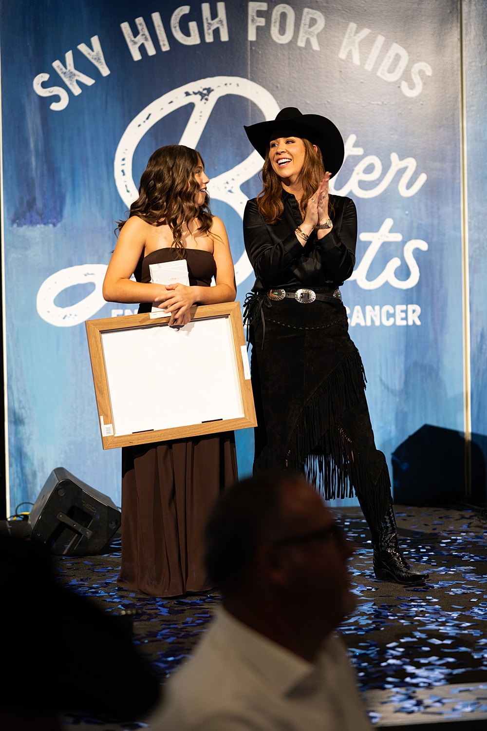 Award ceremony featuring two women on stage.