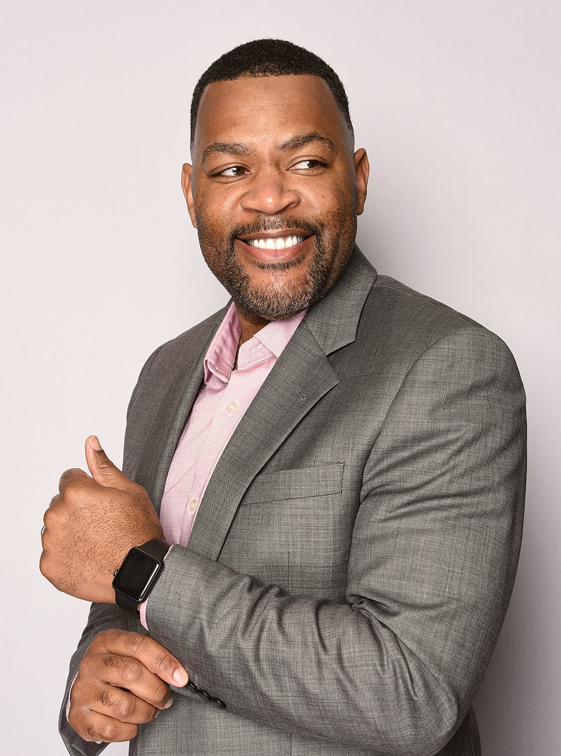 Smiling man in a suit with smartwatch.
