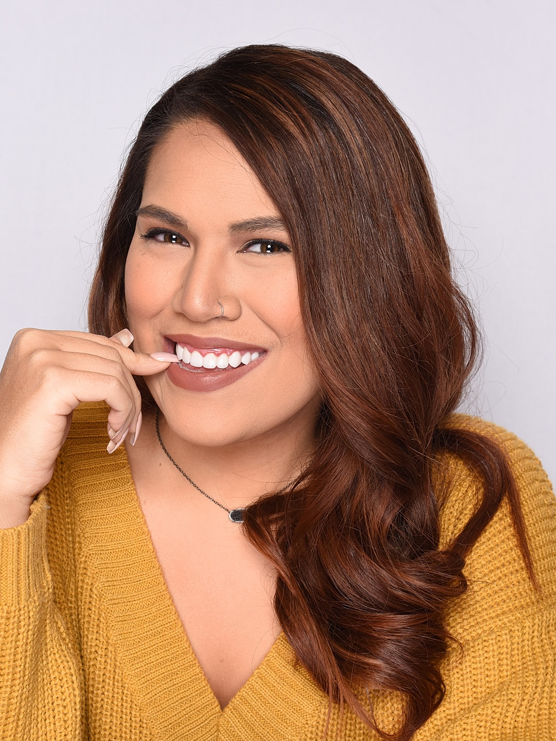 Smiling woman in yellow sweater portrait.