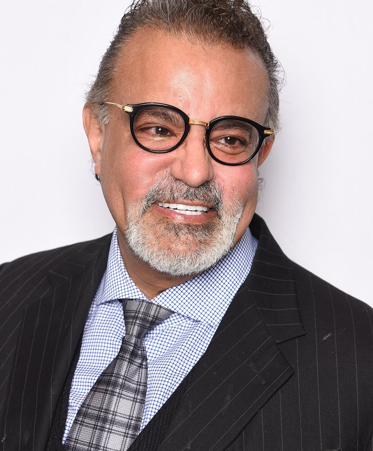 Smiling man in a formal suit and glasses.