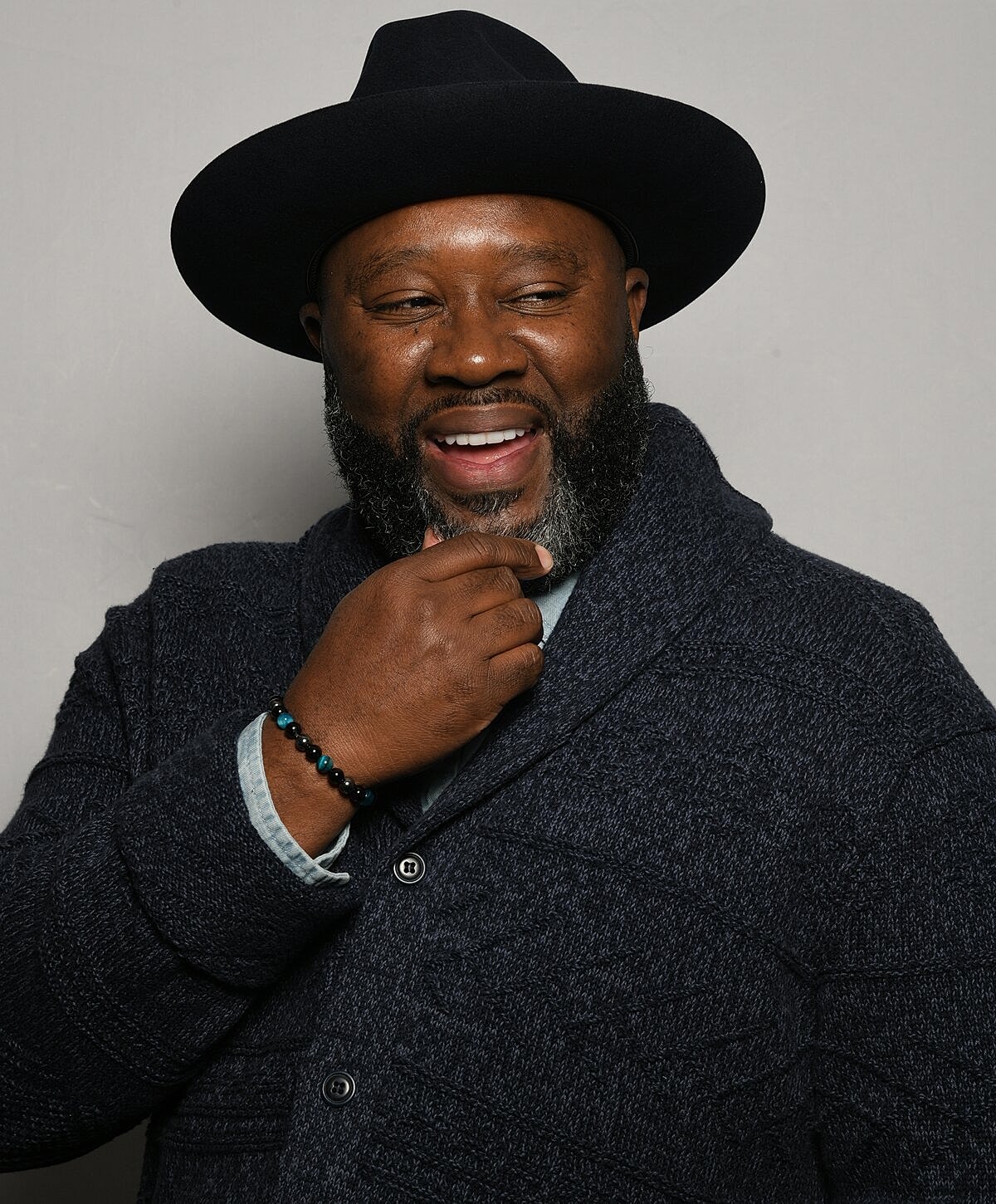 Smiling man in hat and sweater.