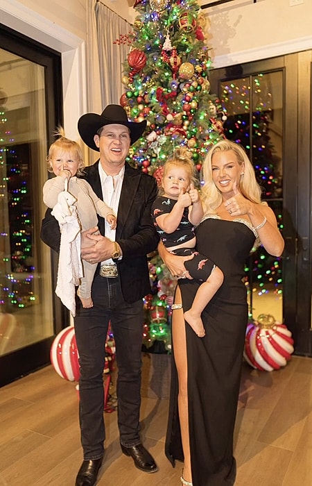 Family portrait by a decorated Christmas tree.
