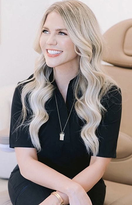 Smiling woman with long, wavy blonde hair.