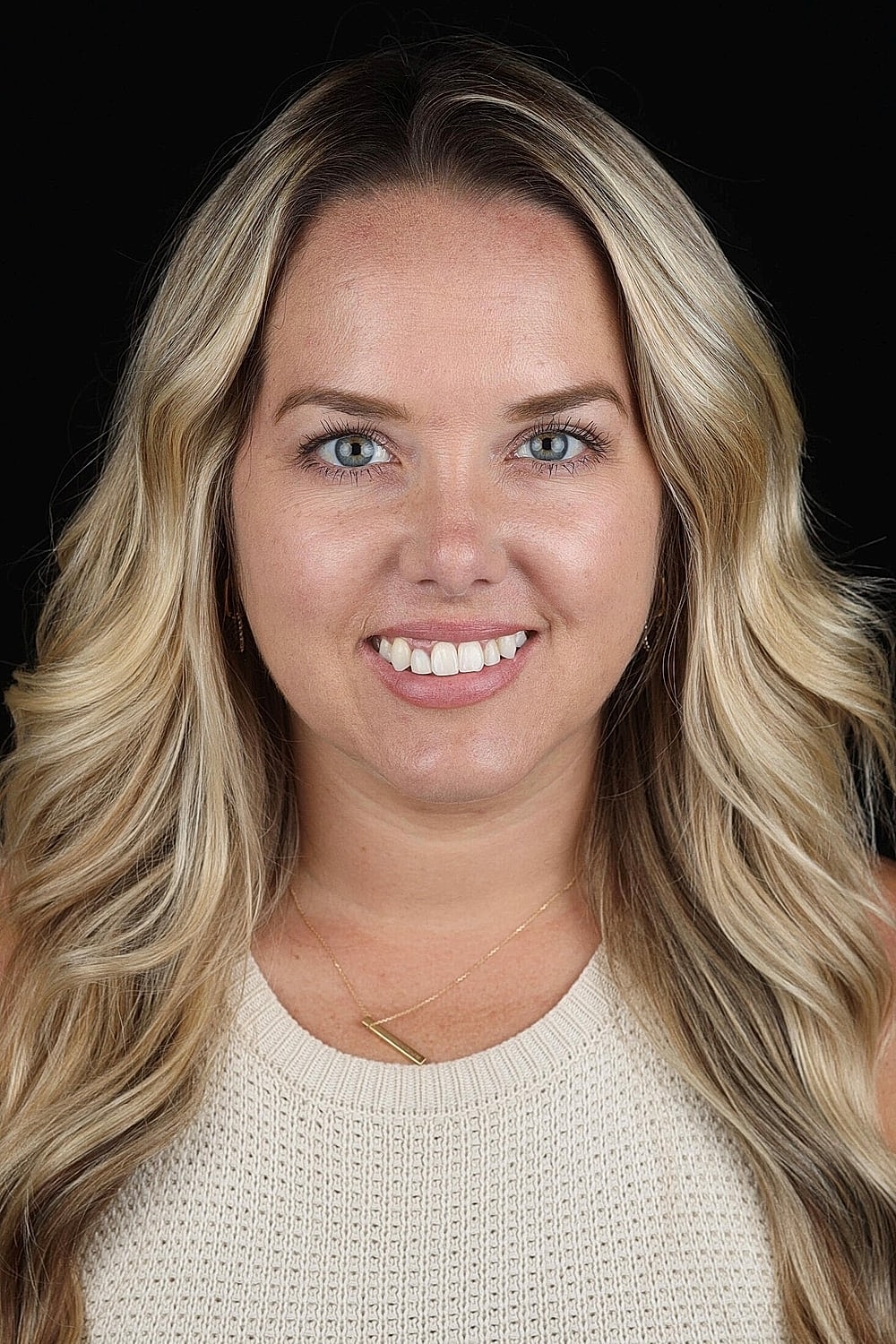 Portrait of a smiling woman with wavy hair.