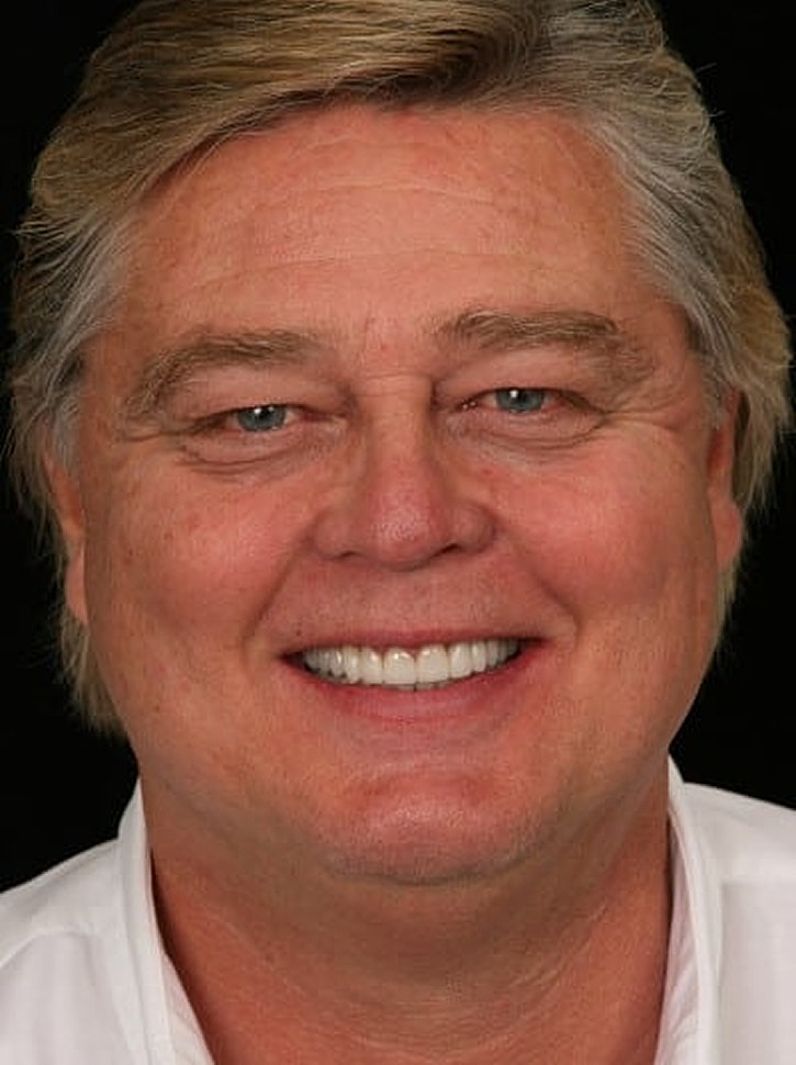 Smiling man with light hair and blue eyes.