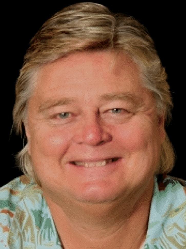 Smiling man with light hair and tropical shirt.