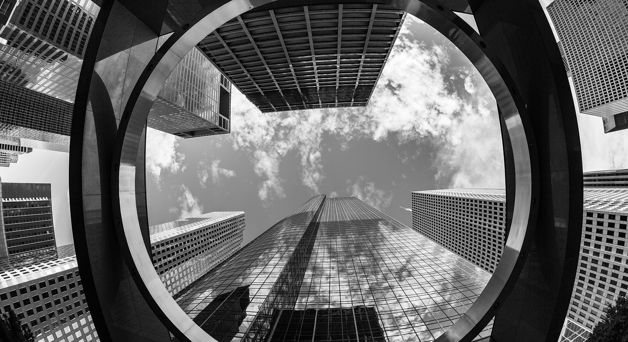 Black and white perspective of skyscrapers and sky.