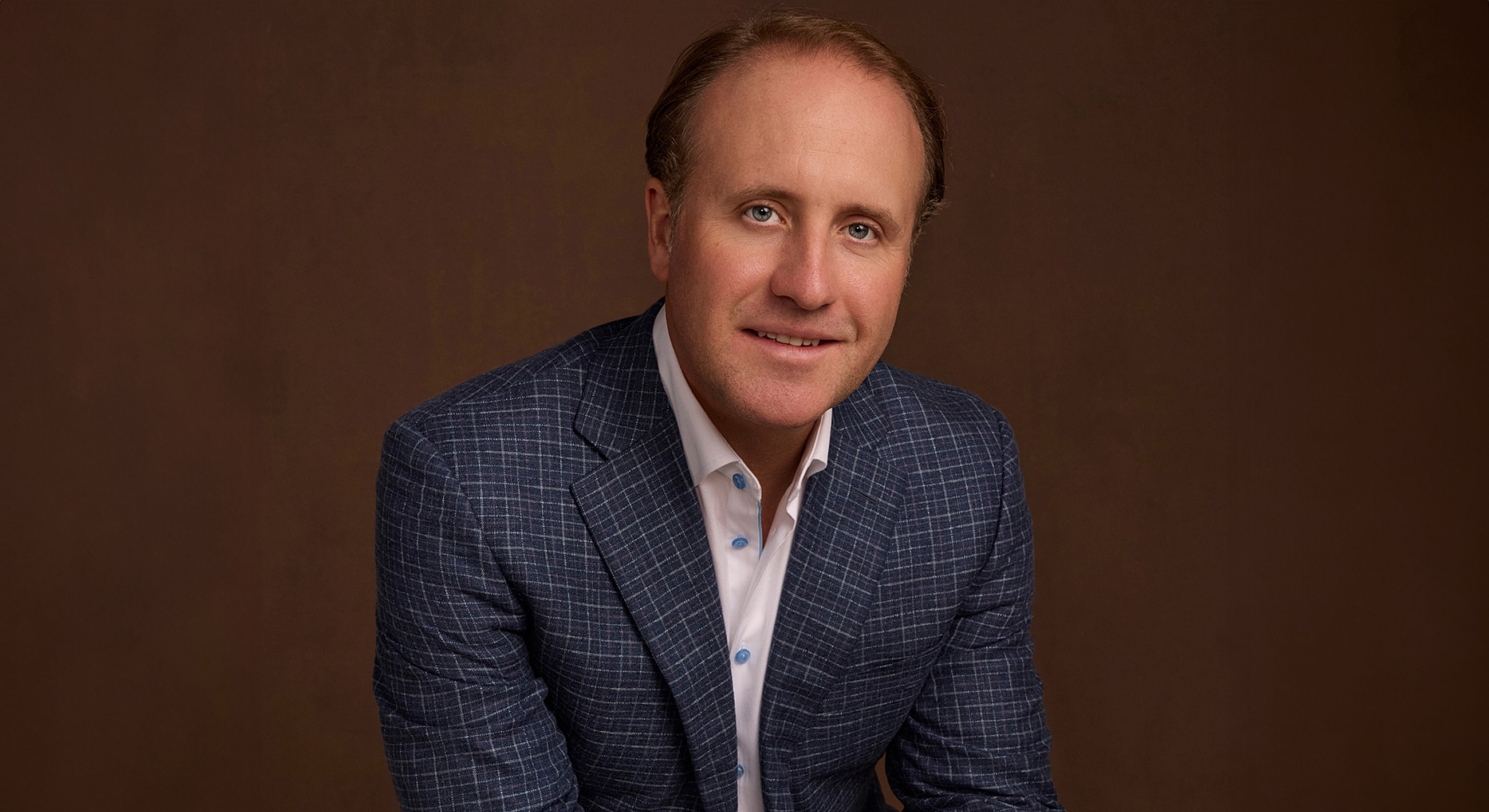 Business professional in a formal blazer setting.